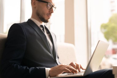 Tuş takımı üzerinde yazarken dizüstü bilgisayar ekranında finansal veya istatistik verileri ile bakarak takım elbise zarif çalışan