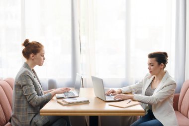 Ciddi konsantre modern iş bayanlar kafede masada oturan ve dizüstü bilgisayarlar ile çalışan