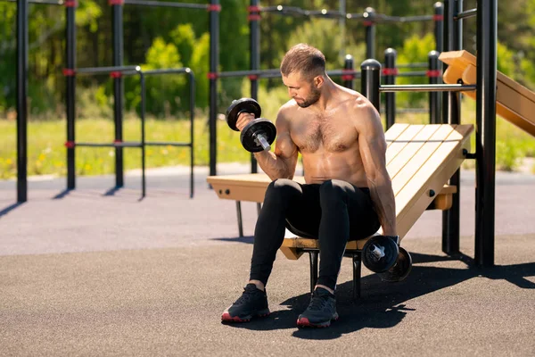 Junger Verschwitzter Muskelsportler Sitzt Auf Sportanlagen Und Trainiert Mit Schweren — Stockfoto