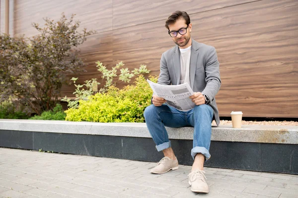 Young Urban Businessman Jeans Jacket Sitting Urban Environment Reading Newspaper — Stock Photo, Image