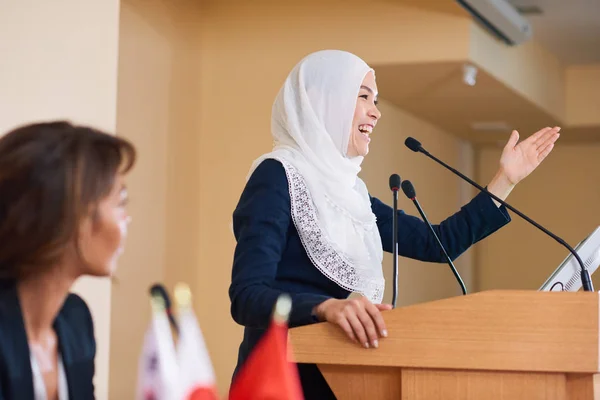 Счастливая Молодая Женщина Оратор Хиджабе Смеется Стоя Трибуны Конференции Разговаривая — стоковое фото