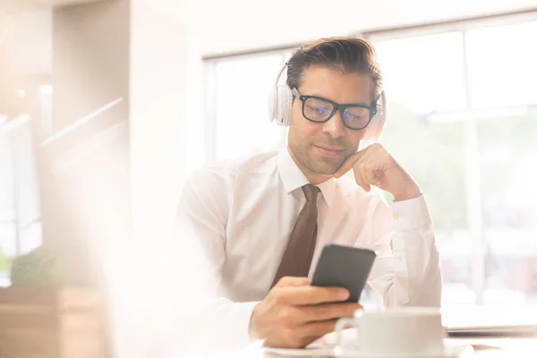 Seriöser Geschäftsmann Mit Kopfhörer Und Formalbekleidung Lokiert Bildschirm Des Smartphones — Stockfoto