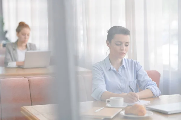 Mujer Joven Concentrada Seria Camisa Azul Sentada Mesa Escribiendo Ideas — Foto de Stock