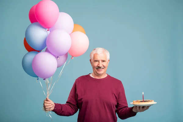 Gelukkige Senior Man Met Stelletje Ballonnen Zelfgemaakte Verjaardagstaart Poseren Studio — Stockfoto