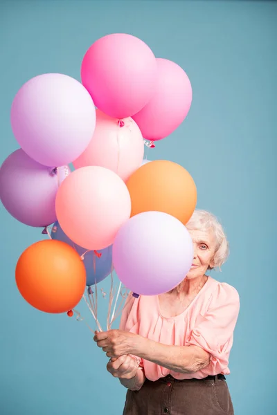 Heureuse Femme Âgée Regardant Hors Tas Ballons Colorés Dans Isolement — Photo