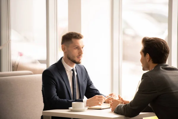 Sério Jovem Empregador Formalwear Ouvir Candidato Enquanto Ambos Sentados Café — Fotografia de Stock