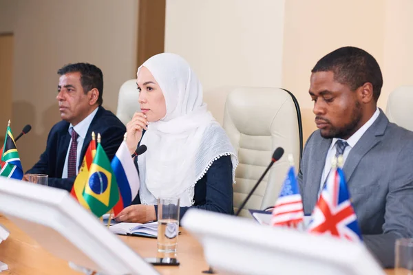 Jovem Delegada Penitente Hijab Ouvindo Dos Colegas Relatar Enquanto Senta — Fotografia de Stock