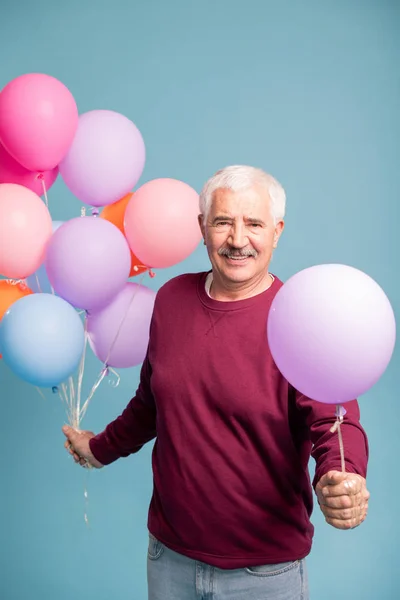 Wesoły Dojrzały Mężczyzna Dający Jeden Balon Pęczek Podczas Stwarzający Niebieski — Zdjęcie stockowe