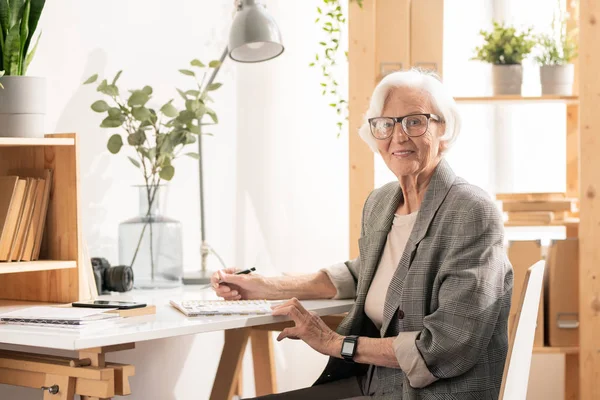 Mutlu Başarılı Yaşlı Kadını Formalwear Gözlük Kamera Önünde Masa Başında — Stok fotoğraf