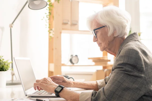 Starsza Kobieta Okularach Zginanie Laptopa Podczas Wyszukiwania Sieci Wideo Online — Zdjęcie stockowe