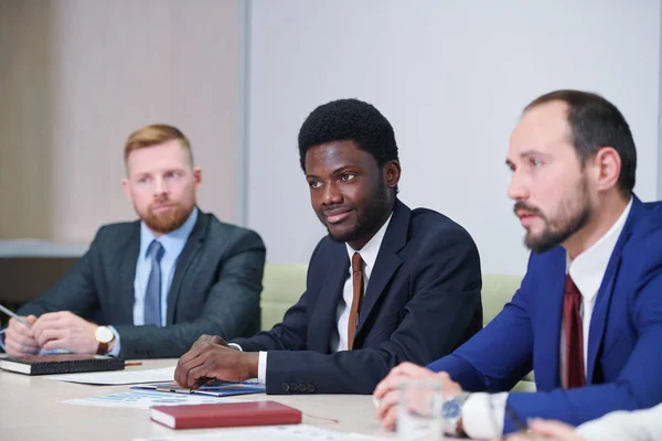 Africký Podnikatel Jeho Kavkazští Kolegové Partneři Poslouchají Přednášející Konferenci — Stock fotografie