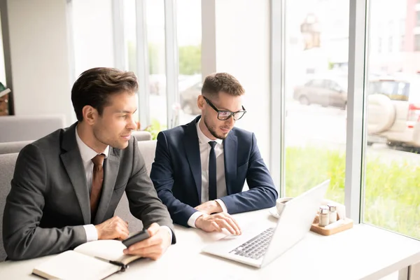 Dos Jóvenes Comerciantes Elegantes Trajes Mirando Través Información Financiera Pantalla — Foto de Stock