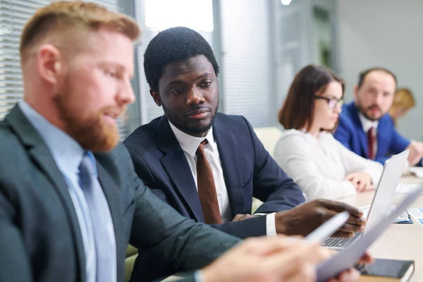 Joven Corredor Africano Mirando Documento Financiero Mientras Que Colega Explicar — Foto de Stock