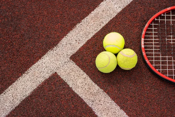 Top view of sports gear for game of tennis on stadium playground by two white lines