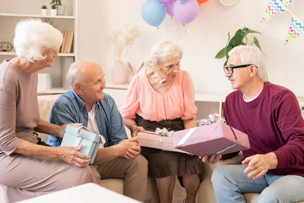 Vier Senioren Von Heute Die Sich Gegenseitig Geschenke Machen Und — Stockfoto