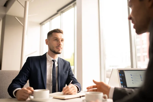 Ung Mäklare Formalwear Lyssnar Sin Kollega Och Göra Anteckningar Notebook — Stockfoto