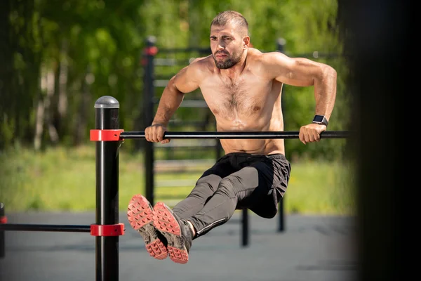 Young Muscular Athlete Exercising Sports Bar While Stretching His Legs — Stock Photo, Image