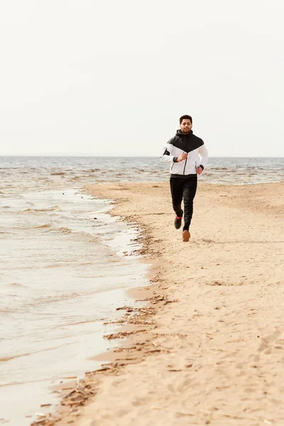 Ung Sportsman Fritidskläder Kör Ner Sandstrand Längs Kusten Sval Sommardag — Stockfoto