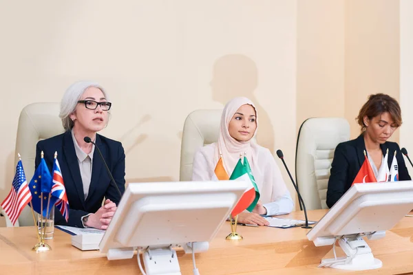 Tres Empresarias Interculturales Ropa Formal Sentadas Mesa Fila Mientras Una — Foto de Stock