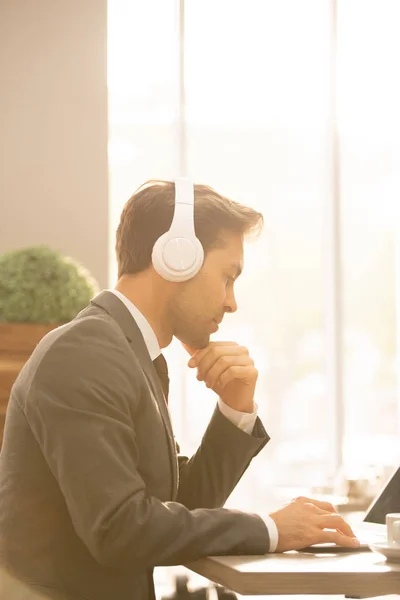 Empresario Serio Corredor Con Auriculares Sentados Junto Mesa Frente Computadora —  Fotos de Stock