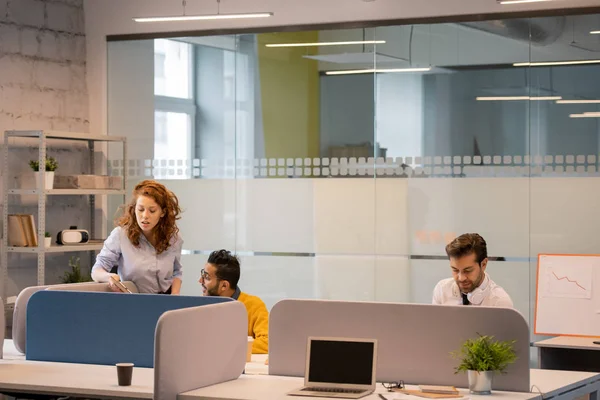 オフィスのテーブルに座って仕事の問題を解決するビジネス従業員のグループ 同僚がデータを操作しながら 同僚にプロジェクトのアイデアを説明する巻き毛の女性 — ストック写真