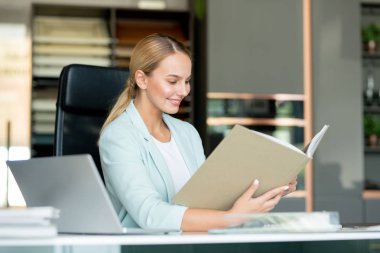 Yeni koleksiyonun albümüne bakarken tasarım ve moda trendlerini inceleyen çağdaş genç tasarımcı