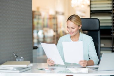 Masa başında kontrol ederken öğrencilerin kağıtları okuma Pretty genç zarif öğretmen