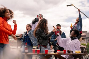 Neşeli genç hokey taraftarları maç yayını sonrası takımlarının zaferini kutlarken bira ile klinking