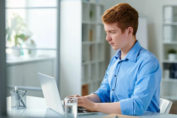 Junger Seriöser Geschäftsmann Schaut Auf Laptop Display Während Auf Tastatur — Stockfoto
