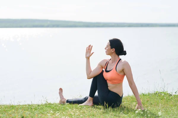 Calm Young Woman Sports Clothing Sitting Grass Lake Keeping Eyes — Stock Photo, Image