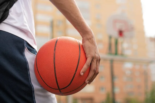 遊び場でトレーニングを行いながらボールを保持する若いプロバスケットボール選手の手 — ストック写真