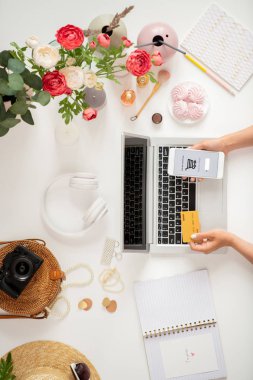 Plastik kart ve akıllı telefon arama ve sepete mal ekleme ile genç mobil müşteri elleri üst görünümü