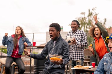 Futbol yayını açık havada izlerken snack bağırarak kendinden geçmiş gençlik çok ırklı grup