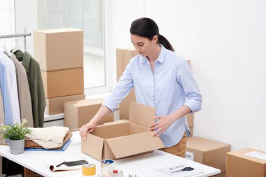Müşteri için yeni casualwear ambalaj ve onları oraya koymadan önce boş kutu açılış online mağaza Yöneticisi