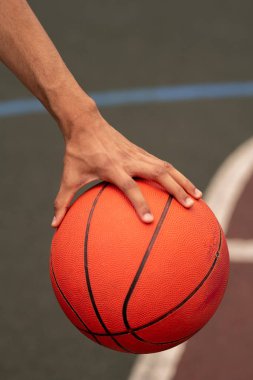Genç aktif basketbolcu sahada oyun sırasında atmak için hazırlanırken topu tutan el