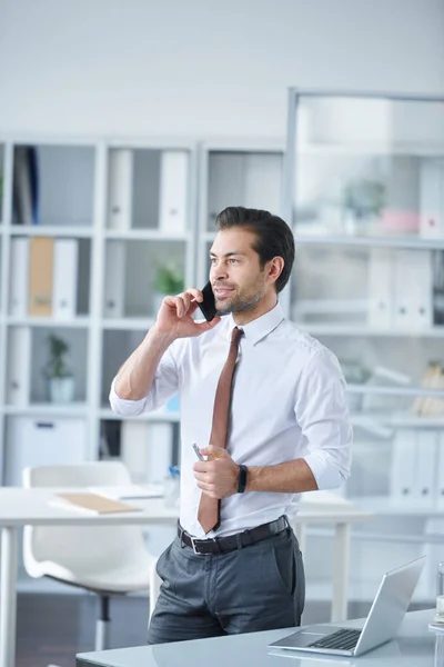 Elegant Ung Agent Consulting Kunder Smartphone Medan Står Vid Skrivbordet — Stockfoto