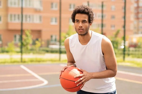 屋外コートや遊び場で試合中にバスケットを見てボールを持つ若いバスケットボール選手 — ストック写真