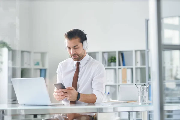 Young Elegant Man Headphones Scrolling Smartphone Workplace Front Laptop — Stock Photo, Image