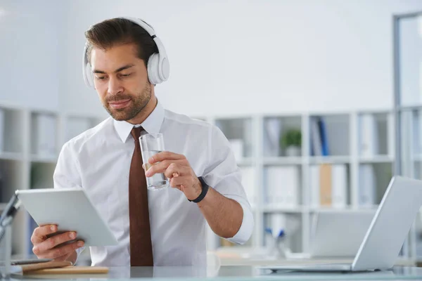 Jonge Serieuze Zakenman Hoofdtelefoons Kijken Naar Tablet Scherm Terwijl Het — Stockfoto