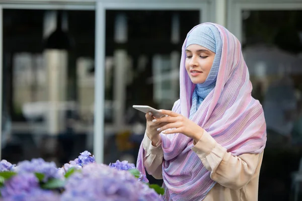 Perempuan Muda Dalam Hijab Mengambil Foto Bunga Kamera Smartphone Sambil — Stok Foto