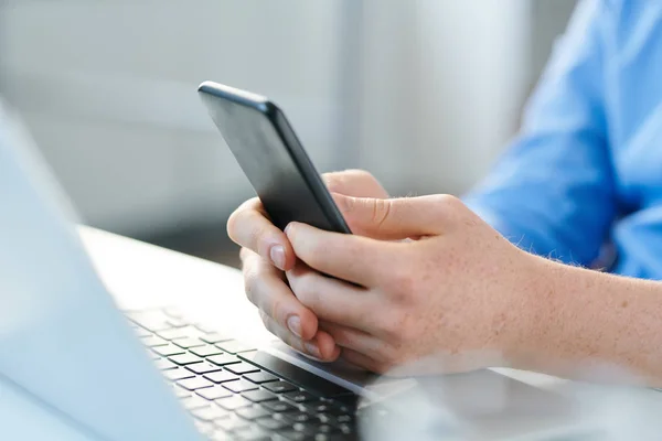 Manos Hombre Joven Con Gadget Móvil Sobre Teclado Portátil Utilizando —  Fotos de Stock