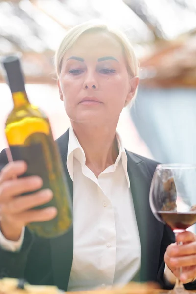 Mature Blonde Woman Formalwear Looking Bottle Cabernet While Estimating Quality — Stock Photo, Image