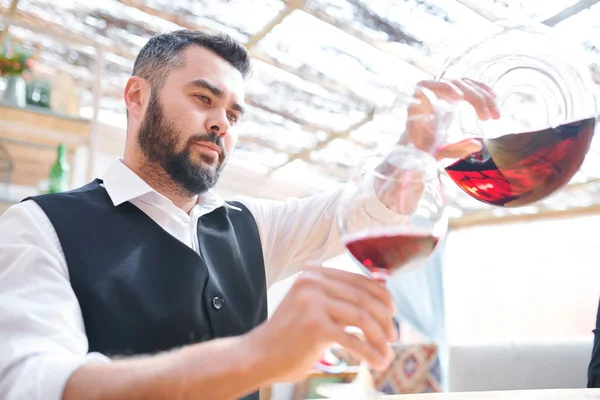 Barman Barbudo Jovem Sommelier Derramando Vinho Tinto Vinho Enquanto Trabalhava — Fotografia de Stock