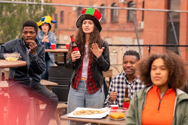 Grupo Tensos Jóvenes Aficionados Interculturales Comiendo Papas Fritas Pizza Mientras —  Fotos de Stock