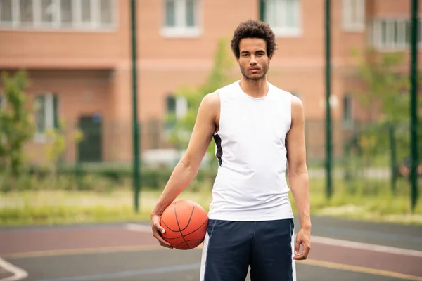 Jonge Knappe Basketbalspeler Met Bal Staande Het Hof Achtergrond Van — Stockfoto