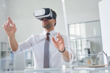 Çağdaş genç işadamı ofiste çalışırken sanal sunum yapıyor