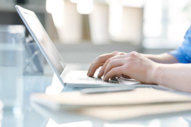 Açık havada gezinirken dizüstü tuş tuşlarına dokunan öğrenci veya genç girişimcinin elleri