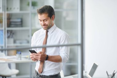 Mobil işadamı ofiste iş günü boyunca akıllı telefon daki kişiler arasında gezinme