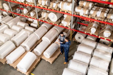 İş kıyafetleri konusunda iki genç teknik uzman, fabrikalarının deposunda yaptıkları toplantıda çalışma anlarını tartışıyor
