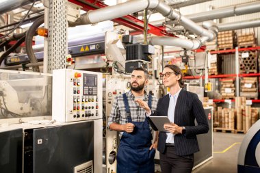 Modern fabrika test tablet ve mühendis ile genç kendinden emin kadın ve petrokimya işleme yeni sistem veya teknoloji tartışıyor